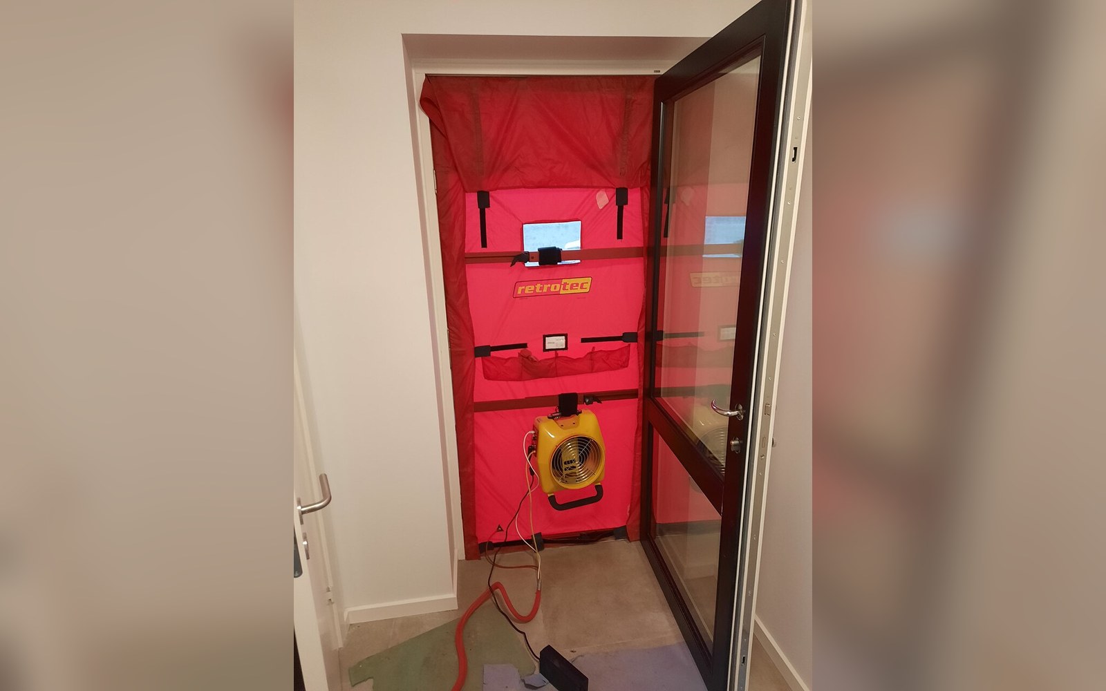 A blower-door fan sealed into a doorway with the panel taped